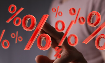 Red percentage symbols floating around a hand, symbolizing discounts, interest rates, or financial...
