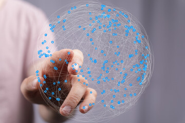 Abstract image of a hand interacting with a digital sphere representing global networking and...