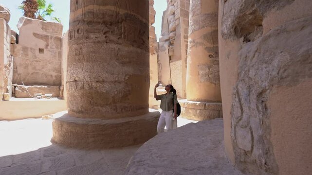 Tourist exploring karnak temple columns montage