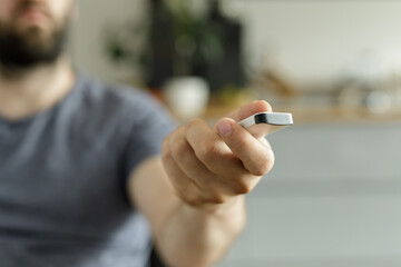 Close-up of a man's hand holding a sleek, modern device.  Technology, gadget, innovation.