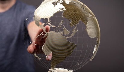 High-quality image of a hand interacting with a transparent 3D model of the Earth, representing...