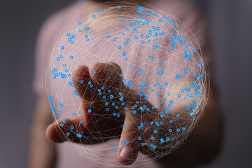 Abstract image of a hand interacting with a digital sphere, representing global connections and...