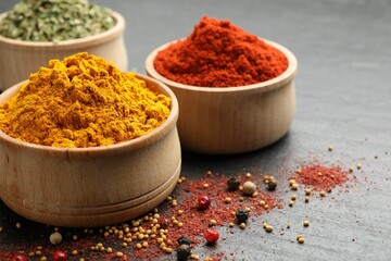 Different aromatic spices on black table, closeup. Space for text