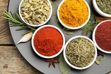 Different aromatic spices on wooden table, top view