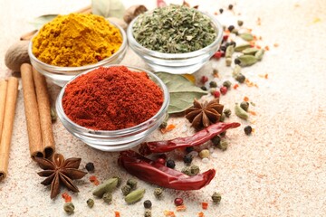 Different aromatic spices on color textured table, closeup. Space for text