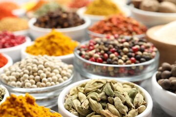 Different aromatic spices in bowls on table, closeup