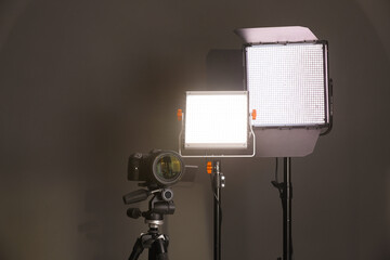 Professional lighting equipment and camera on grey background. Space for text