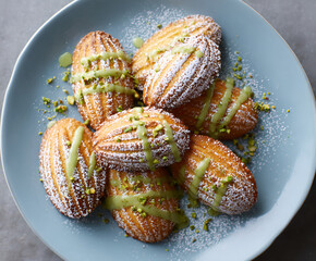 Pistachio drizzle madeleines on a blue plate