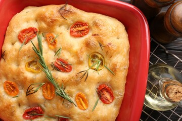 Delicious focaccia with tomatoes, spices and oil on table, flat lay