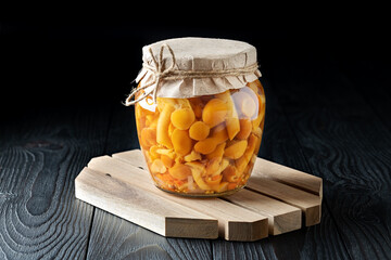 Jar of Pickled Mushrooms on Rustic Wooden Background
