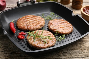 Delicious hamburger patties and spices on wooden table, closeup