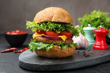 Delicious hamburger with patty served on black table, closeup