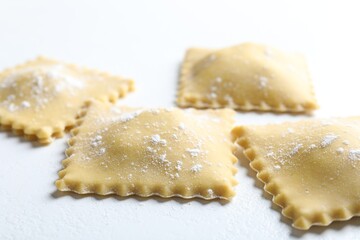 Uncooked ravioli on white table, closeup view