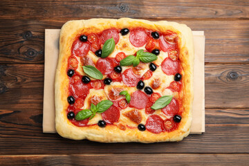 Tasty homemade pizza on wooden table, top view