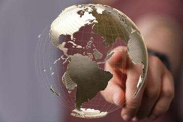 High-quality stock photo of a hand interacting with a 3D model of Earth, representing global...