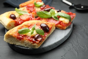 Pieces of tasty homemade pizza on black table, closeup