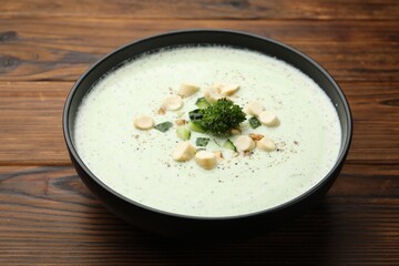 Tasty cucumber soup with croutons and broccoli on wooden table, closeup