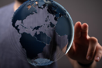 Abstract image of a hand interacting with a digital globe, symbolizing global connectivity and...
