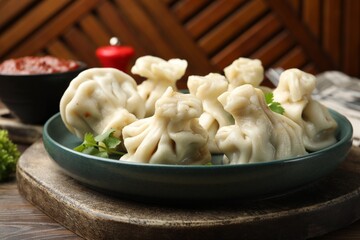 Delicious khinkali served with cilantro on wooden table, closeup