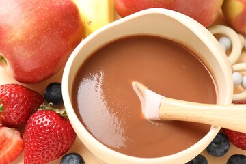 Baby food. Tasty puree in bowl and ingredients on table, above view