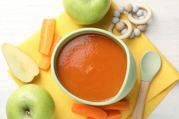 Baby food. Tasty puree in bowl, different ingredients and teether on white table, flat lay