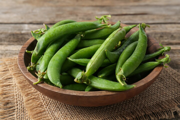 Fresh ripe green peas on wooden table, closeup