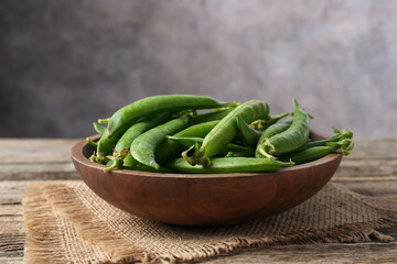 Fresh ripe green peas on wooden table, closeup. Space for text