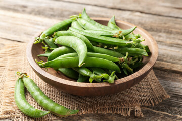Fresh ripe green peas on wooden table, closeup