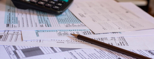 Planning, Budget, and Tax Concept. Individual Income 1040 Tax Form and calculator for individual income. According to United States, season to pay and deadline for tax payment-banner concept.