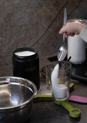Child Measuring Sugar with Spoon While Cooking vertical photo