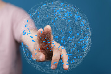 Person's finger touches a digital sphere, representing global network, connection, and technology.