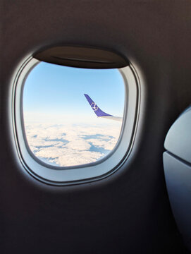 Poland, Warsaw- 04.29. 2025: Wing of LOT Polish Airlines plane above clouds, view from airplane window