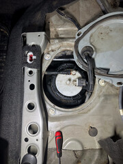 Exposed car fuel pump assembly with wiring and connectors during diagnostics or replacement, top view.