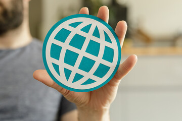 Image of a hand holding a teal globe icon, representing internet, global connection, and worldwide...