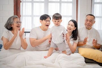 Fototapeta premium Family joy as toddler takes first steps in cozy room during afternoon gathering