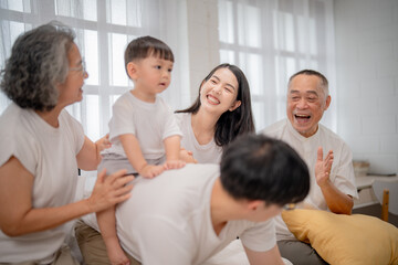Fototapeta premium Family gathering filled with joy and laughter as members interact with a young child in a cozy indoor setting