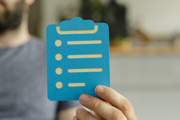 Person holding a blue checklist clipboard.  Perfect for task management, to-do lists, and...