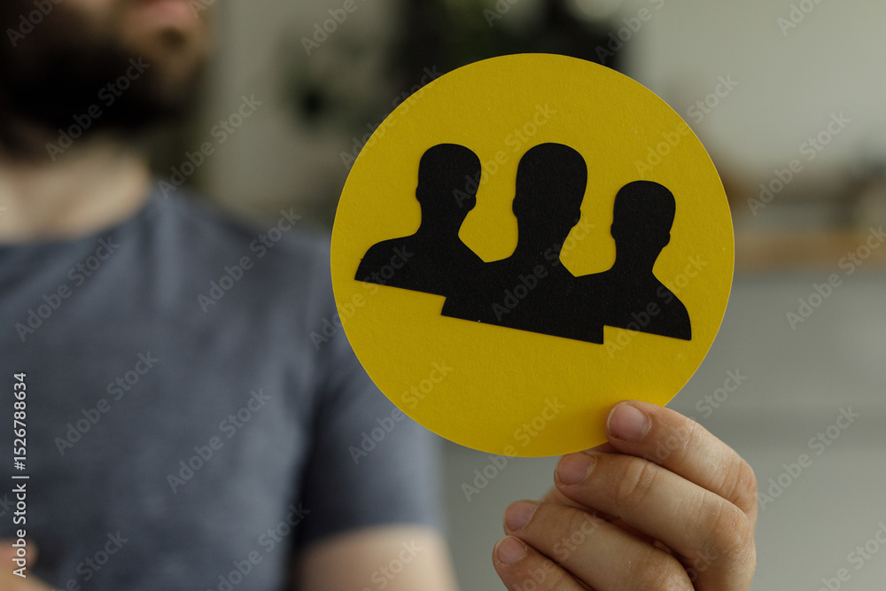 Poster image of a person holding a yellow circle with three black silhouettes representing teamwork and col