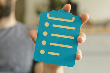 A hand holds a blue checklist icon.  Perfect for project management, task organization, and...