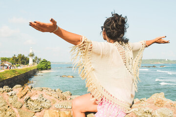 Woman tourist sit enjoy panoramic Lookout from UNESCO Galle Fort. Galle Fort Walk with Ocean Views concept. Sightseeing landmark and popular visit destination in Sri lanka