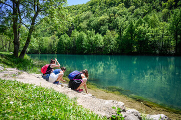 Family is freshening up in the river Una on a mountain hike in Bosnia. Mother and children are resting by river Una on a hike to Strbacki buk waterfalls in Bosnia and Herzegovina.