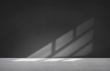 A black and white photo of a room with a window shadow