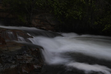 Side view of flowing water over rocks. Slow shutter speed to make water look silky