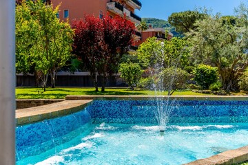 Vibrant garden with blue tiled fountain.