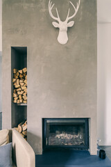 A cozy fireplace featuring a deer head mounted on the wall above it