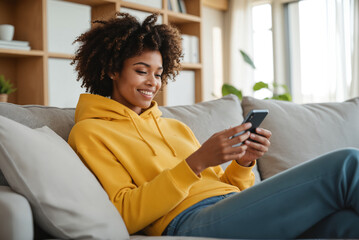 African American Woman Shopping Online - Smartphone and Credit Card on Cozy Sofa for E-Commerce, Mobile Banking, and Digital Retail Platforms
