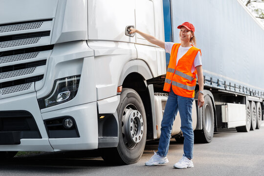 Portrait young adult happy smiling woman heavy truck driver modern cargo vehicle cabin background. Female person girl professional job career working driving freight engine lorry. Logistics industry