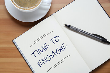 Time To Engage phrase written in notebook and coffee on wooden desk, top view