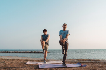 Fototapeta premium Men doing exercise together and sporty active outside sea beach