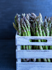 Green Asparagus in Wooden Crate. Harvested green asparagus neatly arranged in a weathered gray crate, ideal for market or farm visuals